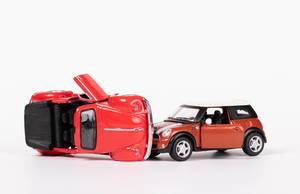 Das Konzept von Autounfall: zwei rote Spielzeugautos an einem Unfall beteiligt