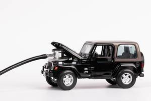 Das Konzept von Autowartung: ein Stethoskop auf dem Motor von einem schwarzen Jeep