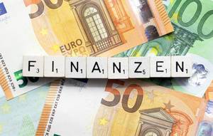 Das Wort Finanzen aus Würfelbuchstaben auf Euroscheinen