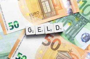 Das Wort Geld aus Würfelbuchstaben auf Euroscheinen