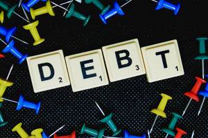 Debt (Schuld) Text auf flachem Untergrund fotografiert