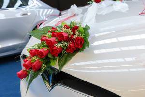 Decorated wedding car with flowers / red roses on the hood of Tesla Model X P90DL