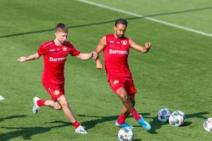 Defender Mitchell Weiser and football colleague Karim Bellarabi fight for the ball during training session in Germany