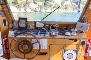 Dekorierter Steuerraum mit hölzernem Steuerrad, eines Schiffs auf griechischem Gewässer