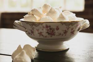 Delicate china bowl with meringue cookies