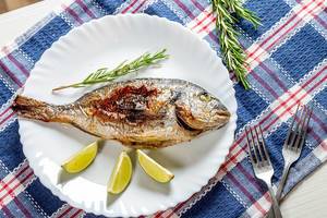 Delicious cooked Dorado fish with slices of lime and a sprig of rosemary (Flip 2019)