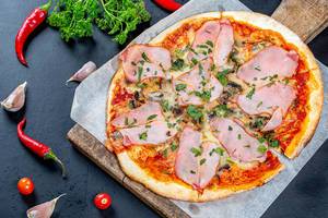 Delicious fresh pizza with ham and mushrooms