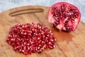 Delicious Fresh Pomegranate seeds on the wooden board