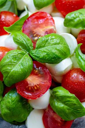 Delicious italian caprese salad with ripe tomatoes, fresh garden basil and mozzarella cheese (Flip 2019) (Flip 2019)