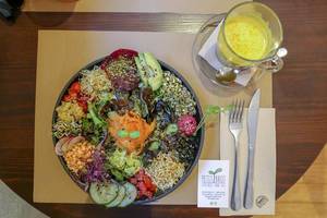 Der Salat "Ensalada del Sol" im veganen Petit Brot Restaurant in Barcelona, Spanien, mit Sauerkraut, marinierten Pilzen, rosa Hummus und Avocado