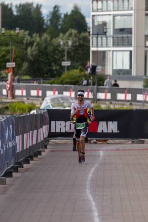 Der Schweizer Profiläufer Manuel Kueng, kurz bevor er die Bronzemedaille erhält, läuft die Marathonstrecke des Ironman 70.3 in Lahti, Finnland