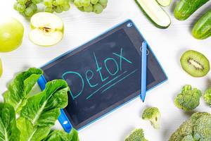 Detox-Konzept: Frische, grüne Früchte und Gemüse auf weißem Holzhintergrund