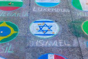 Die Israelische Flagge mit Münzen auf dem Boden auf dem Platz des Kölner Weihnachtsmarktes