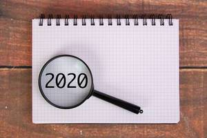 Die Jahreszahl 2020 auf einem Karoblock, vergrößert dargestellt unter einer Lupe