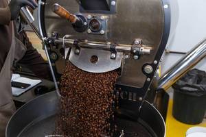 Diedrich-Maschine schüttet ganze Kaffeebohnen auf ein großes Sieb zum Mahlen