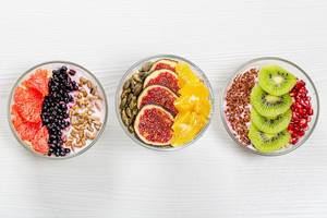 Different Breakfast options with oatmeal, fresh fruit and seeds. Top view