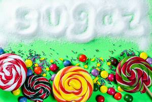 Different sweets on a green background with the inscription Sugar