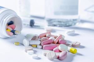 Different tablets and pills in yellow, pink and white
