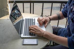 Digitaler Nomade arbeitet in Café in Vietnam an Laptop