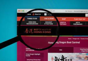 Discover Hong Kong website on a computer screen with a magnifying glass