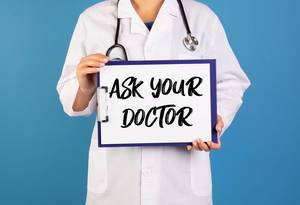 Doctor holding clipboard with Ask your doctor text