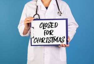 Doctor holding clipboard with Closed for Christmas text