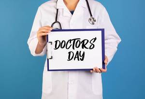 Doctor holding clipboard with Doctors day text