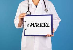 Doctor holding clipboard with Karriere text