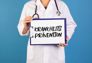 Doctor holding clipboard with Krankheitsprävention text
