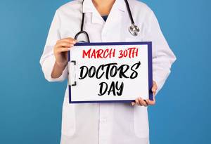 Doctor holding clipboard with March 30th Doctors day text