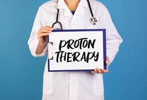 Doctor holding clipboard with Proton Therapy text