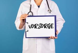Doctor holding clipboard with Vorsorge text