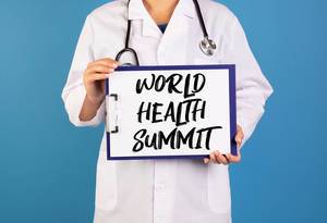 Doctor holding clipboard with World health summit text