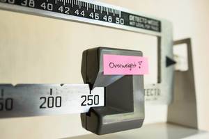 Doctor scale showing 250 pounds as OVERWEIGHT