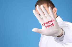 Doctor wearing medical gloves with Coronavirus text