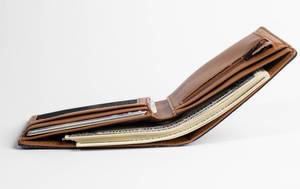 Dollar bills in brown leather wallet