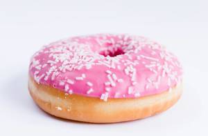 Donut with pink topping close up on a white background