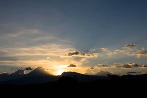 Dramatischer Sonnenuntergang hinter Vulkanbergen