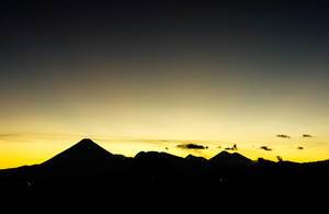 Dramatischer Sonnenuntergang hinter Vulkanen in Guatemala