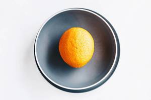 Draufsicht einer Orange auf grauem Teller
