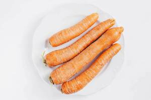 Draufsicht von ungeschälten Karotten vor weißem Hintergrund