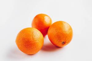 Drei reife Orangen vor weißem Hintergrund