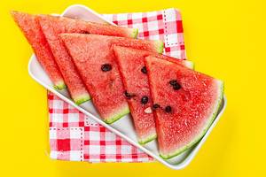 Dreiecke Wassermelonen-Stücke, vor gelben Hintergrund