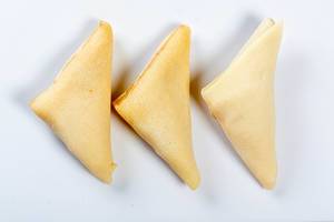 Dreieckige Pfannkuchen mit Füllung, auf einer weißen Oberfläche