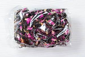 Dried Crimean black tea with pink flower petals in a package