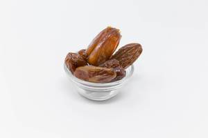 Dried Dates in glas bowl on white background