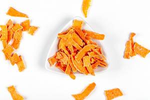 Dried pumpkin slices in a white bowl, top view (Flip 2020)