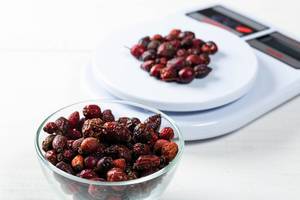 Dried rose hips in a glass bowl and on a kitchen scale