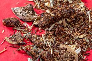 Dried tea with dragon fruit on red background