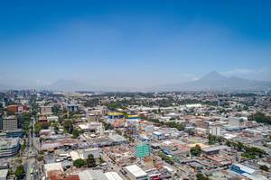 Drohnenaufnahme von Guatemala City und dem dahinter liegenden, imposanten Vulkan